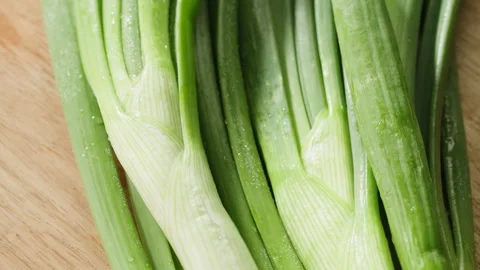 Bunch of green onion feathers with drops of water on a cutting board, Close-up Stock Footage 242522027