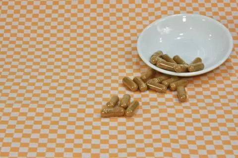 A bunch of green tea, on leaf capsules or pills on dishes. Stock Photos