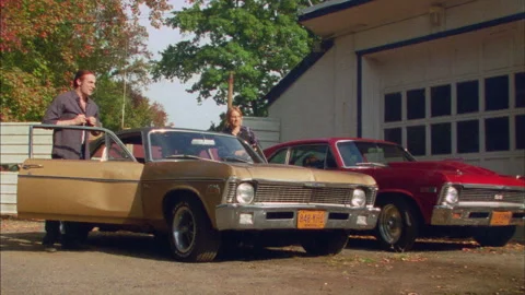 A bunch of guys get into a  car and drive down the street Stock Footage 272272676