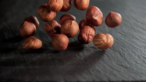 A bunch of hazelnuts falling on a slate table Stock Footage 152383918