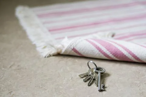 Bunch of keys left on the doorstep under the carpet Stock Photos