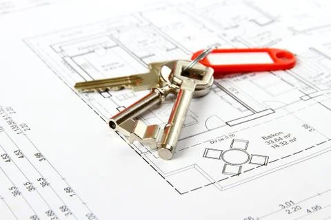 Bunch of keys with red keychains at architectural drawing Foto stock