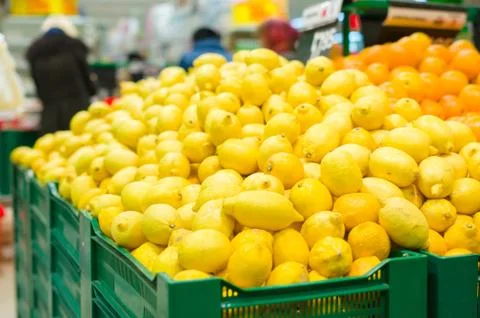Bunch of lemons and oranges on boxes in supermarket Stock Photos