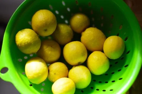 BUNCH OF LEMONS IN A GREEN STRAINER/ COLLANDER Stock Photos