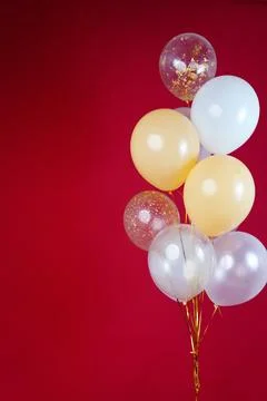 A bunch of light balloons on a red background. Vertical Photo Space for Text Foto stock