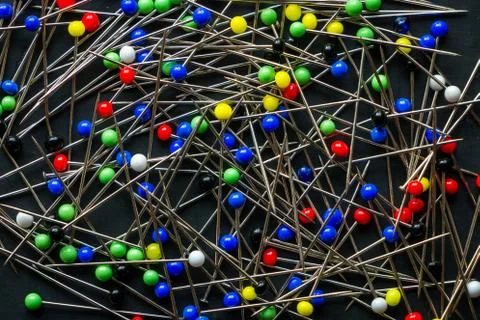 A bunch of multi colored round head pins on a black background Stock Photos