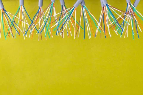 A bunch of multi-colored wires on the background of mustard-colored surface Stock Photos