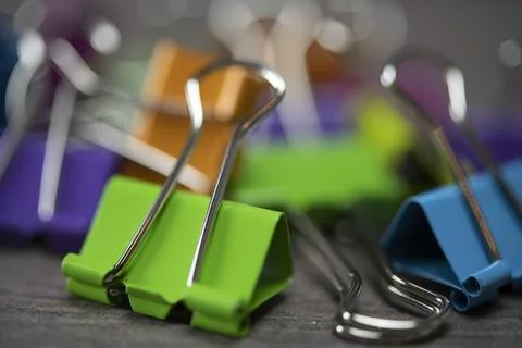 Bunch of multicolored binder clips on table Stock Photos