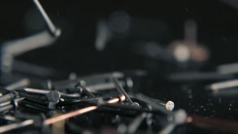 Bunch of nails falling on the black table on black bg in slow motion Stock Footage 103112246