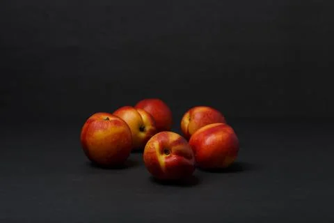Bunch of nectarines on black table against black background with copy space Stock Photos