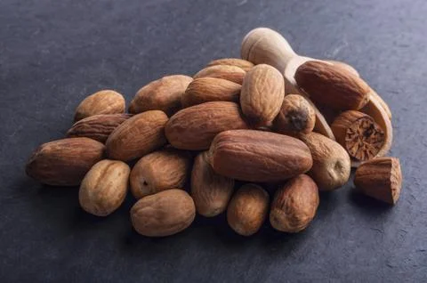A bunch of nutmeg on black stone background Stock Photos