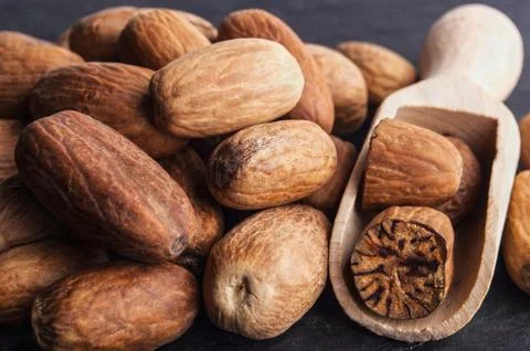 A bunch of nutmeg on black stone background Stock Photos