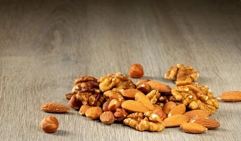 A bunch of nuts - hazelnuts, walnuts and almonds on a wooden table Stock Photos