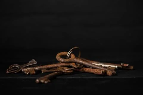 Bunch of old metal keys on a table, low key. Theme of collecting and vintage Stock Photos