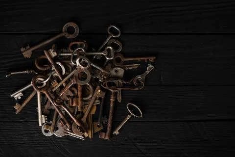 Bunch of old metal keys on a table, top view, low key Fotos Stock
