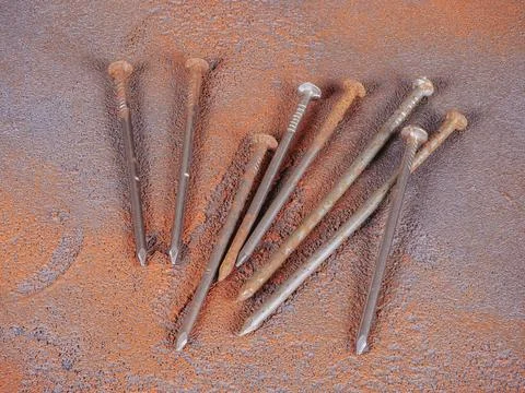 Bunch of old rusty nails on orange rough background Stock Photos
