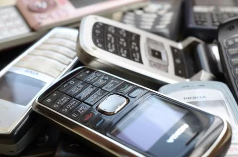 Bunch of old used outdated mobile phones. Recycling electronics in the market Stock Photos
