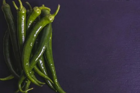 A bunch of pepper on a black stone tile Stock Photos