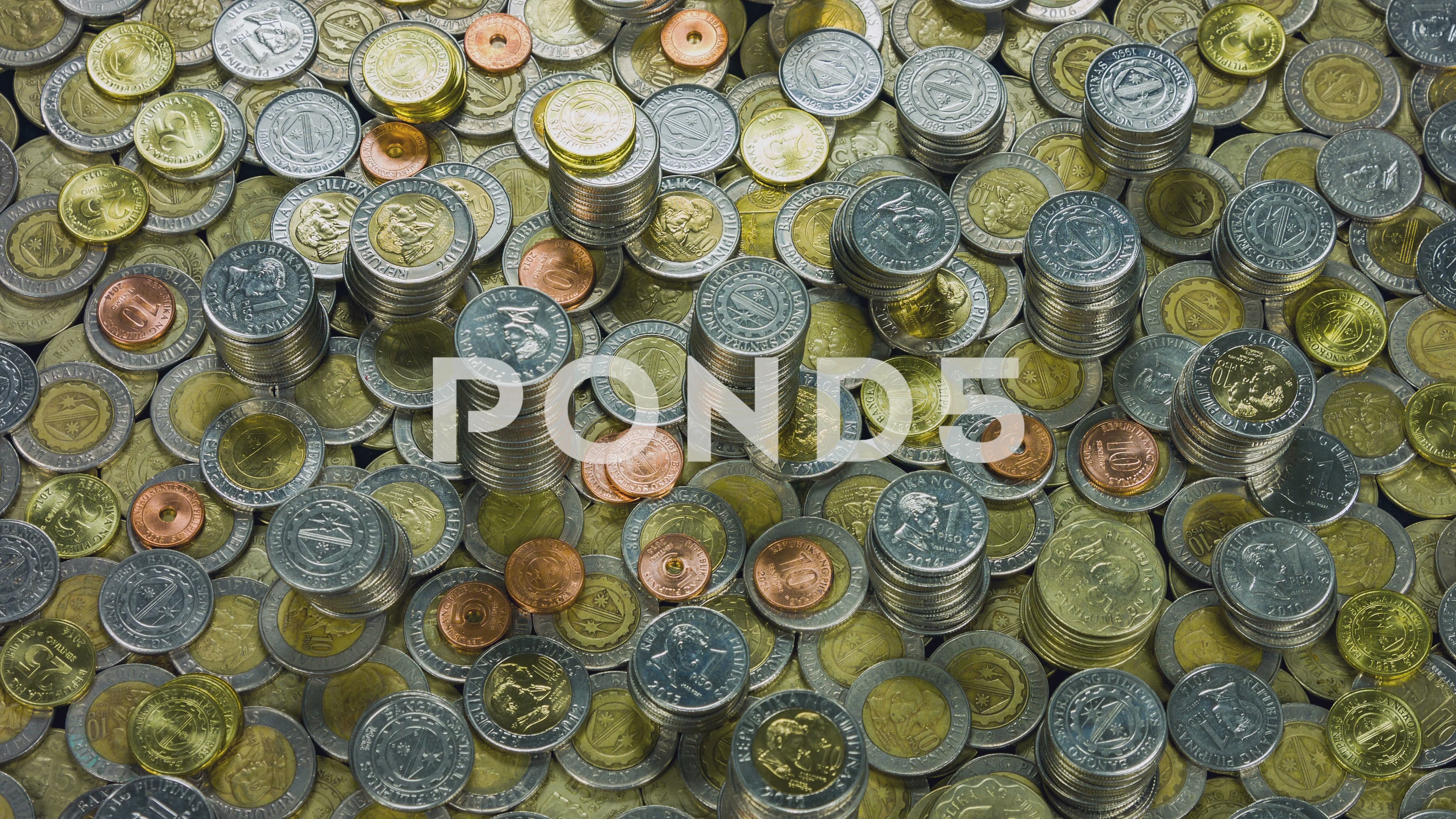 A pile of new and old Philippine peso coins with one thousand