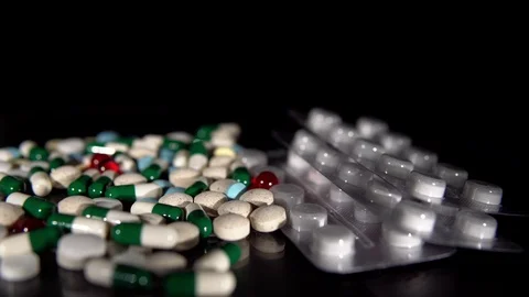 A bunch of pills on a black background Stock Footage 114126943