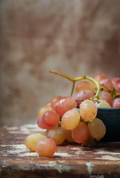 Bunch of pink grapes over rustic background Stock Photos