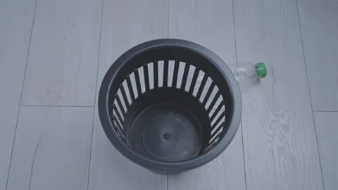 Bunch of plastic bottles falling in small black rubbish bin Stock Footage 257955765