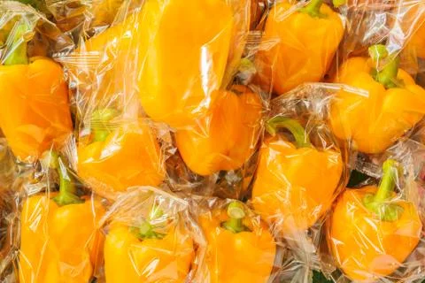 Bunch of plastic wrapped bell peppers Photos