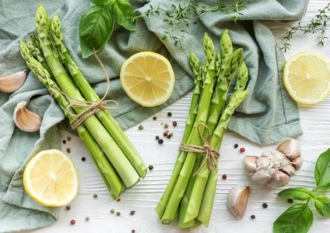 Bunch of raw asparagus stems with different spices Foto stock