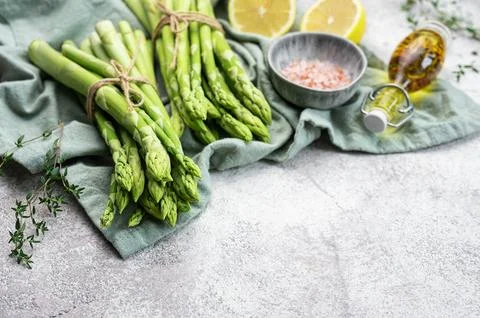 Bunch of raw asparagus stems with different spices Foto stock