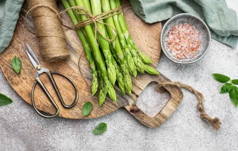Bunch of raw asparagus stems with different spices Stock Photos