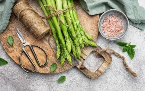 Bunch of raw asparagus stems with different spices Stock Photos
