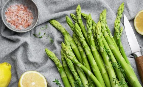 Bunch of raw asparagus stems with different spices Stock Photos