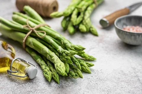 Bunch of raw asparagus stems with different spices Foto stock