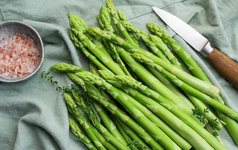 Bunch of raw asparagus stems with different spices Foto stock