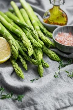 Bunch of raw asparagus stems with different spices Foto stock