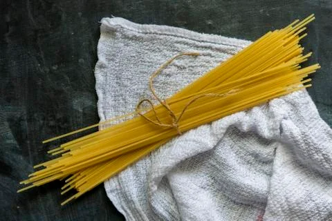 Bunch of raw spaghetti top view, flat lay on dark surface Stock Photos