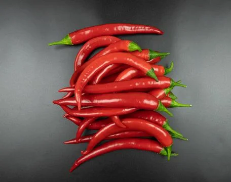 A bunch of red chili peppers on a black background, top view Stock Photos