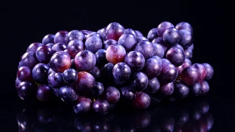 Bunch of red grapes rotates on black mirror background in 4K. Closeup view shot. 動画素材 78069364