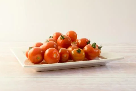 Bunch of red mini tomatoes on a square plate Foto stock