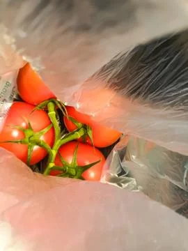 A bunch of red tomatoes packed in plastic. Stock Photos