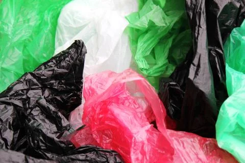A bunch of reusable, multi-colored plastic bags polluting the environment. Stock Photos