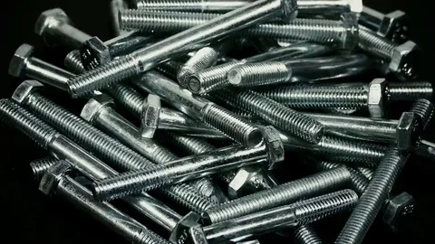 Bunch of screws on a rotating plate, isolated on black background Stock Footage 69108915