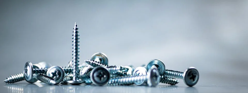 A bunch of self-tapping screws on the table. Stock Photos
