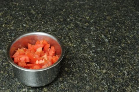 A bunch of sliced, diced, and cut red tomatoes inside of a round metal bowl r Stock Photos
