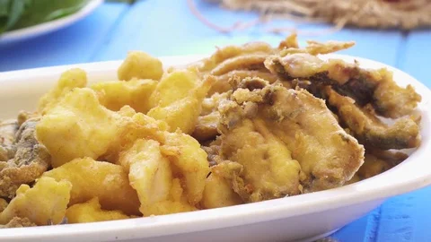Bunch of small fried fish in plate. Close up macro view Greek style blue table Stock Footage 80312788