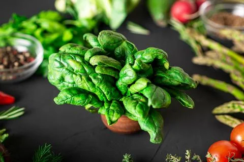 Bunch of spinach. Various vegetables on the background in blur. Healthy, vege Stock Photos