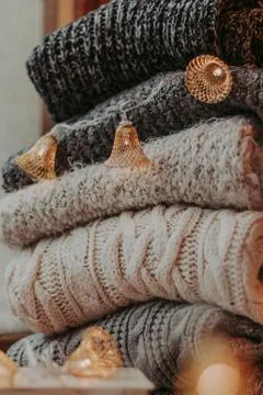A bunch of sweaters, light bulbs, lanterns, cozy winter interior details, hom Stock Photos
