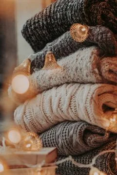A bunch of sweaters, light bulbs, lanterns, cozy winter interior details, hom Stock Photos