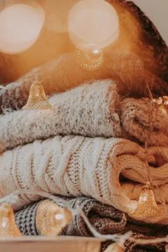 A bunch of sweaters, light bulbs, lanterns, cozy winter interior details, hom Stock Photos
