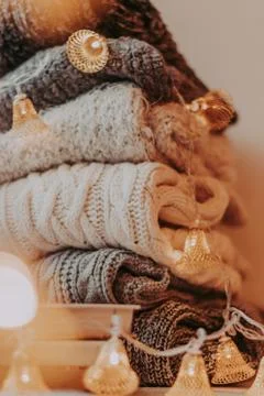 A bunch of sweaters, light bulbs, lanterns, cozy winter interior details, hom Stock Photos